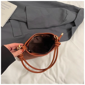 Internal view of brown embossed leather bag showing dark fabric lining and zip pockets