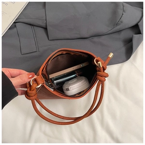 Spacious interior of brown crocodile pattern bucket bag holding phone and lipstick