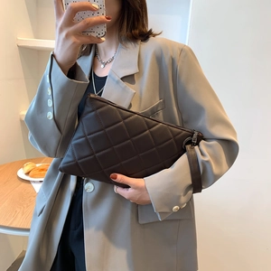 Chocolate brown quilted envelope bag with chic chain strap and wristlet on wooden table