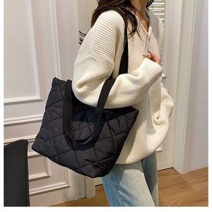 Détail du sac cabas matelassé noir avec motif à losanges et large bandoulière en tissu