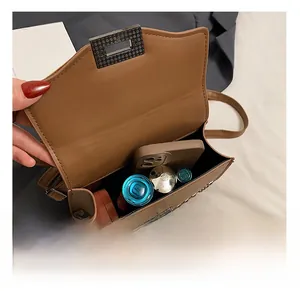 Macro view of brown leather bag interior showing capacity for phone and cosmetics