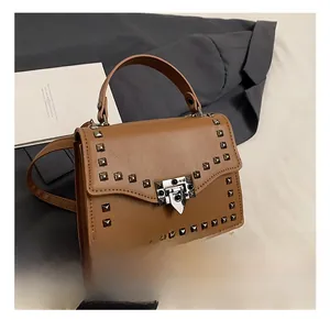 Detail of brown faux leather bag featuring square metallic rivets and vintage clasp lock