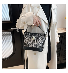 Detail der Leoparden-Beuteltasche mit goldenem Verschluss und schwarzem Ledergriff