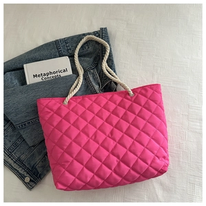 Dettaglio della borsa tote trapuntata rosa con manici in corda di cotone bianco e occhielli
