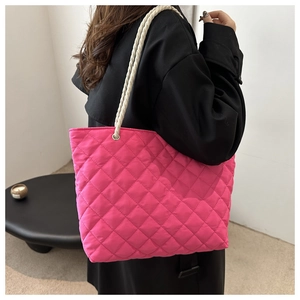 Détail du cabas matelassé rose rouge avec une poignée en coton tressé blanc épais