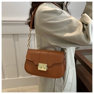Detail of vintage brown stone pattern shoulder bag with gold clasp on model