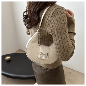 Détail du sac demi-lune crème avec nœud argenté sur simili cuir texturé pour femme