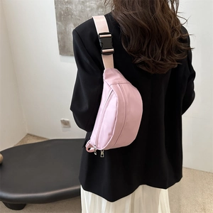 Modern pink nylon crescent waist bag with adjustable wide strap worn on a black blazer