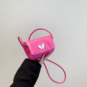 Pink quilted mini crossbody bag with white butterfly detail and slim top handle
