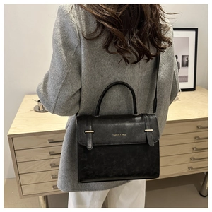 Chic black textured leather flap crossbody bag with gold hardware and top handle strap