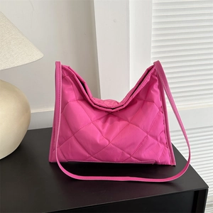 Pink quilted nylon tote bag with rhombus pattern on a minimalist indoor setup