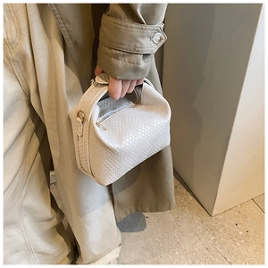 Detail der cremefarbenen Webstruktur und des Griffs dieser eleganten PU-Leder-Kissentasche