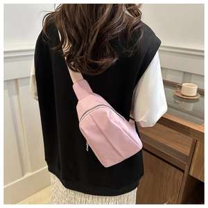 Detailed back view of pink nylon crossbody bag with silver zipper and adjustable strap