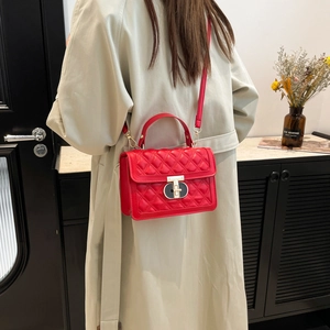 Red quilted crossbody bag with gold hardware and top handle for women in minimalist style