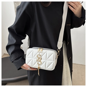 Detail of white quilted crossbody bag with golden SS logo and metallic fringe tassel