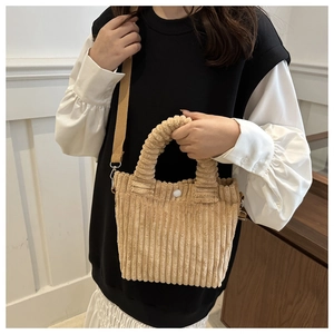 Detail view of beige corduroy tote with spiral handle and detachable shoulder strap