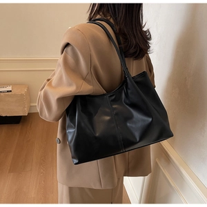 Detail view of large black PU leather tote bag with vertical stitching and soft texture