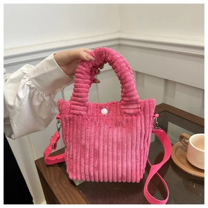 Detail of rose pink corduroy tote bag showing metal snap button and soft fabric texture