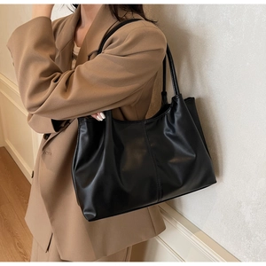 Detail of black pleated tote bag with decorative stitching and large capacity