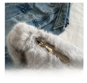 Dettaglio macro della cerniera dorata sulla borsa tote in peluche grigio