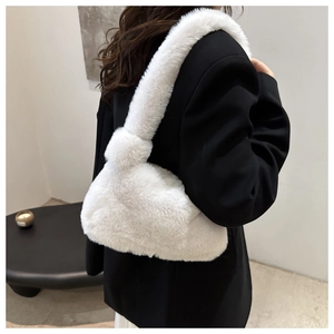 Vista posteriore della modella con borsa in peluche bianca su una giacca nera
