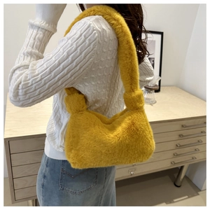 Dettaglio della borsa tote in peluche gialla con tracolla annodata e morbida consistenza pelosa