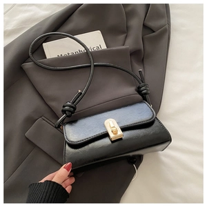 Detail of vintage baguette bag featuring navy blue wrinkled leather and gold clasp