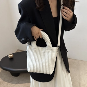 White corduroy crossbody bag with pleated handle and shoulder strap on model