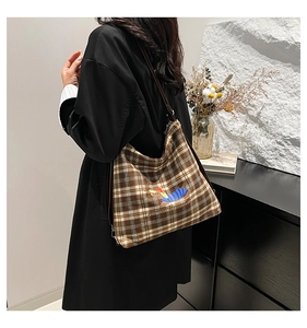Détail du sac cabas en toile à carreaux avec illustration de teckel et bandoulière marron