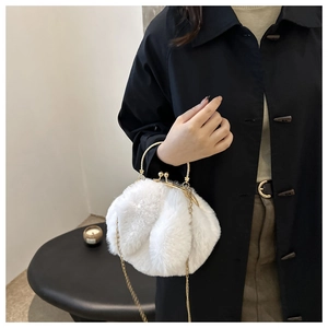 Détail du sac à main en peluche blanche avec oreilles de lapin et poignée dorée