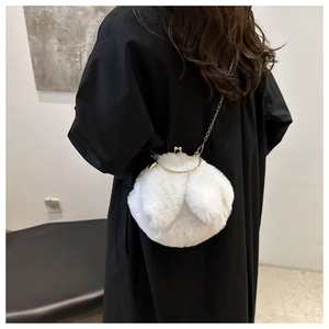 Détail du sac à main blanc en fausse fourrure avec fermoir baiser doré et poignée