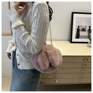 Détail du sac en peluche rose avec oreilles de lapin, poignée et chaîne dorée