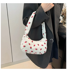 Gros plan d'un sac sous le bras en velours côtelé à imprimé fraises sur un mannequin
