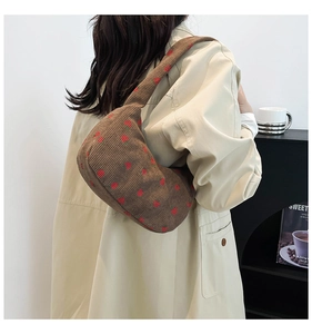 Détail du sac hobo en velours côtelé à imprimé fraise montrant la texture douce