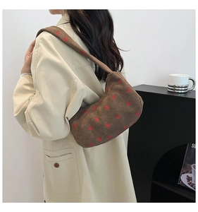 Sac à bandoulière en velours côtelé marron à fraises porté avec un trench beige