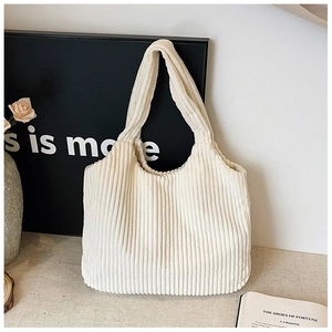Textura detallada del bolso tote de pana blanco crema con rayas verticales y estilo minimalista