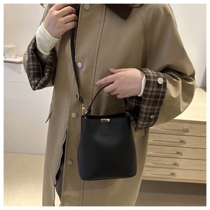 Dettaglio della borsa a secchiello nera opaca con goffratura fashion e fibbia magnetica