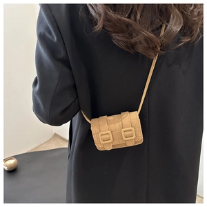 Detail of khaki croc-embossed mini crossbody bag styled on a black blazer outfit