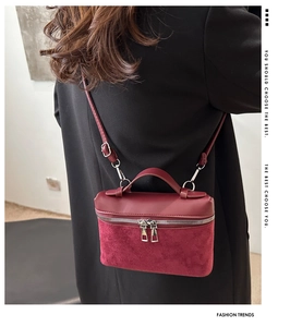Detail of burgundy bucket bag featuring smooth leather and suede patchwork design