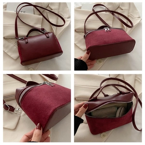 Detail view of burgundy bucket bag showing split leather texture and dual zipper closure