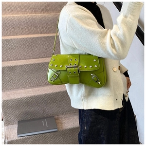 Détail du sac à bandoulière vert brillant avec rivets argentés et boucles métalliques