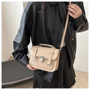 Dettaglio della borsa quadrata vintage beige con fibbia in metallo e manico superiore