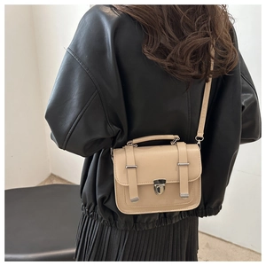 Vista posteriore dettagliata di una borsa a tracolla retrò beige con fibbie argentate