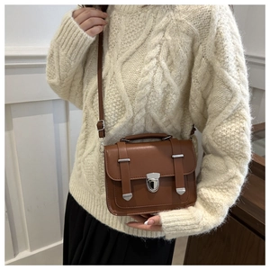 Detail of vintage brown messenger bag with silver twist lock and adjustable strap