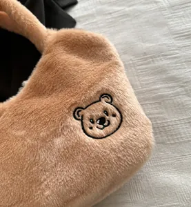 Gros plan détaillé du sac cabas en peluche camel avec broderie d'ours noir mignonne