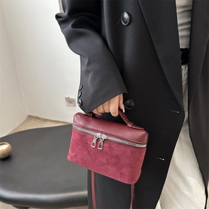 Chic burgundy mini bucket bag with smooth and suede textures and silver dual zippers