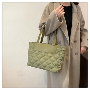 Detail of the olive green quilted tote bag with diamond stitching and fashion patch