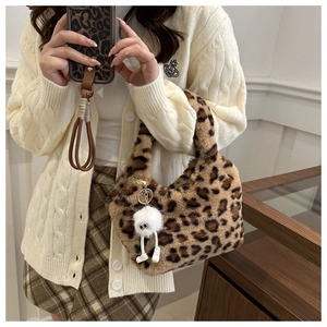 Détail du sac à main en peluche léopard avec pendentif monstre blanc et texture douce