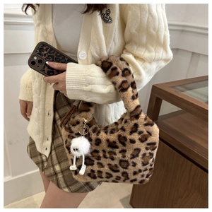 Vue détaillée du sac à main en fausse fourrure léopard avec charme en peluche et coque