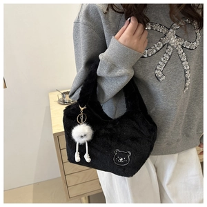 Détail du sac à main noir en fausse fourrure avec broderie ours et pendentif pompon blanc